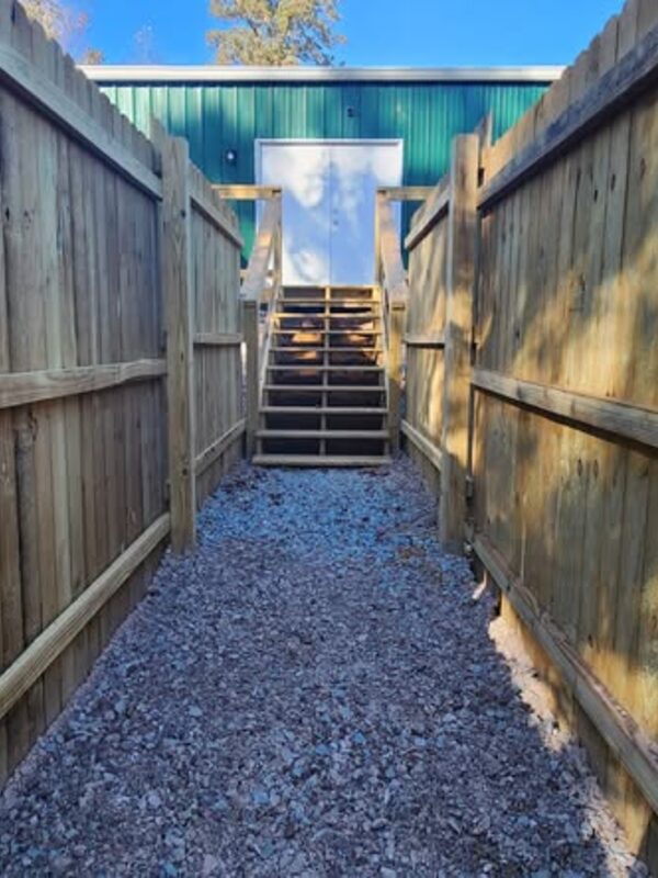A fenced gravel run between the play yards